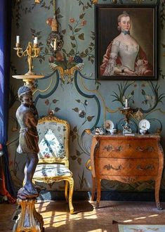 an ornately decorated room with a painting on the wall and antique furniture in front of it