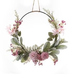 a wreath with flowers and greenery hanging from a rope