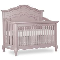 a pink crib with white sheets and pillows