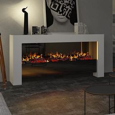 a living room with a fire place in the center and pictures on the wall above it