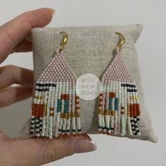 a pair of beaded earrings is being held up to show the inside of it