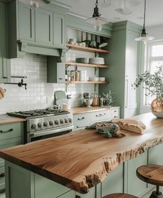 a kitchen with green cabinets and wooden counter tops in front of a stove top oven