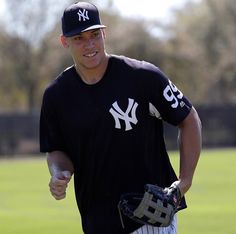 a baseball player wearing a new york yankees uniform and holding a catchers mitt