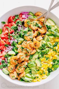 a salad with shrimp, avocado and tomatoes