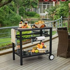 an outdoor table on a deck with food and drinks under an umbrella in the sun