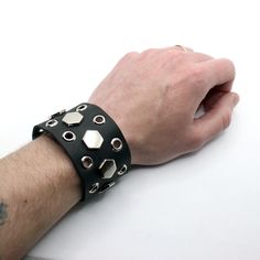 "Gex - medium width , soft and flexible leather cuff decorated by metal eyelets and big hexagons. Easy to close with fast snap buttons. Standard size fit hand sizes - 16-18.5 cm (6.3-7.3\"). Thickness approx. 2mm. Other items ---------------------------------------------------------- Cuff watches Raven https://www.etsy.com/listing/515566876/dark-raven-watch-with-extra-wide-leather Double buckled cuff https://www.etsy.com/listing/678376987/aviator-cuff-oldschool-design-double Matador wide cuff ht Edgy Leather Bracelet With Rivets For Gift, Edgy Leather Bracelet With Rivets, Leather Punk Cuff Bracelet For Festival, Metal Leather Bracelet With Rivets For Festival, Edgy Leather Wristband Gift, Leather Jewelry With Rivets For Gifts, Leather Jewelry With Rivets As A Gift, Edgy Leather Bracelet For Festivals, Leather Silver Jewelry For Concert