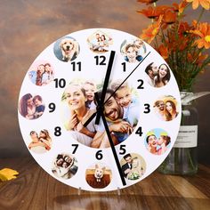 a white clock with pictures of people on it and flowers in front of the clock