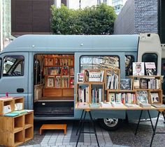 a blue van parked in front of a building filled with books