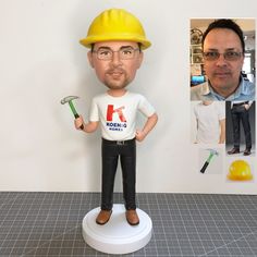 a bobble head with a man holding a hammer and wearing a hard hat on top of it