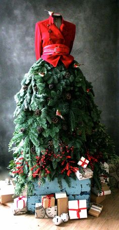 a christmas tree that is sitting on top of a box with presents around it and a red jacket