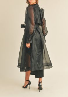 This sophisticated Organza Puff Sleeve Sheer Trench Coat features a double-breasted closure, with a self-tie belt to give you a custom fit. The sheer, long sleeves and organza puff detail bring a touch of elegance to the look. Layer this timeless design over any outfit for an elevated finish. SELF: 100% POLYESTER CONTRAST: 100% RAYON Dress Outerwear, Long Organza Jacket, Sheer Trench Coat, Sheer Layers Fashion, Mesh Trench Coat, Coat Closures Ideas, Transparent Coat, Organza Outfit Ideas, Coat Over Dress