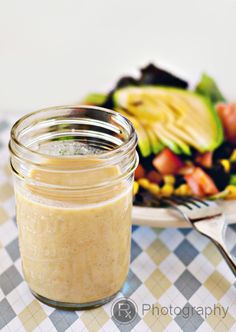 a jar filled with food sitting on top of a table next to a plate of salad