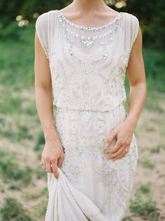 a woman in a white dress is standing outside