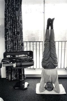 a person doing a handstand in front of a window