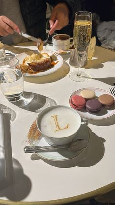 a table topped with desserts and wine glasses filled with liquid on top of it