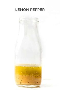 a glass jar filled with yellow liquid on top of a white table