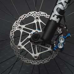 the front wheel of a bicycle with disc brakes and blue hubs on it