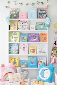 a child's room with bookshelves and toys on the shelves above them