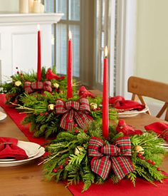 an image of a table setting with candles and greenery on it for christmas dinner