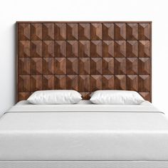 a bed with wooden headboard and pillows on top of it, in front of a white wall