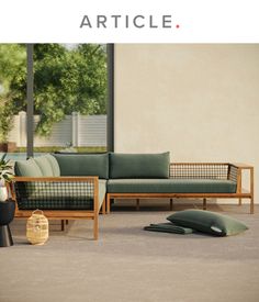 a couch sitting on top of a carpet covered floor next to a plant and potted tree