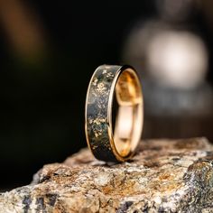 two wedding rings sitting on top of a rock