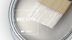 a white paint can with a wooden brush in it's mouth and the words white pepper on top