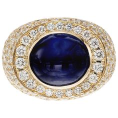 David Webb Mid-Century sapphire and diamond cocktail ring. GIA certified 14.4 carat top color bright blue oval cabochon Sri Lanka Sapphire center stone with 134 round brilliant cut accent diamonds. 18k yellow gold cocktail setting. This beautiful rich blue sapphire is certified by the GIA as a Natural star sapphire with no indications of heat. A pure work of art and perfect example of the 1960's cocktail ring. Distinct Star plus great color Since 1948, David Webb has been the quintessential Amer Luxury White Gold Diamond Cabochons, Luxury Cabochon Diamond Ring For Formal Occasions, Luxury Sapphire Ring With Round Stone, Yellow Gold Diamond Cabochons Fine Jewelry, Luxury Diamond Cabochons For Formal Occasions, Luxury Formal Cabochon Diamond Ring, Luxury Round Cabochon Diamond Ring, Oval Diamond Cabochons For Formal Occasions, Luxury Blue Round Cabochons