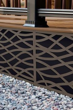 a close up of a metal fence with rocks and gravel on the ground next to it