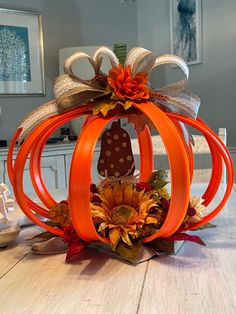 an orange pumpkin decorated with sunflowers and fall leaves