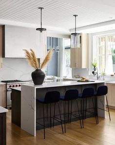 a modern kitchen with an island and bar stools