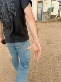 a man standing in front of a house holding his hand out