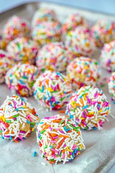 sprinkle covered donuts are on a baking sheet and ready to be eaten