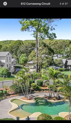 an aerial view of a house with a pool in the foreground and lots of trees