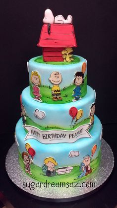 a three tiered cake decorated with peanuts and charlie the pooh characters on it