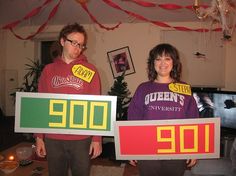 two people holding signs that say 99 / 90 and the number 009 in front of them