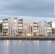 an apartment building sitting on the edge of a body of water