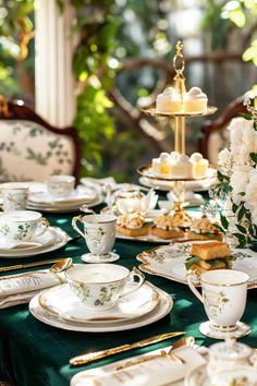 a table set with tea cups, saucers and plates