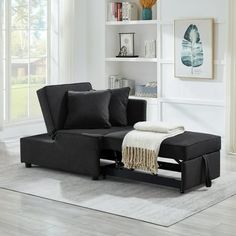 a living room with a black couch and white rug