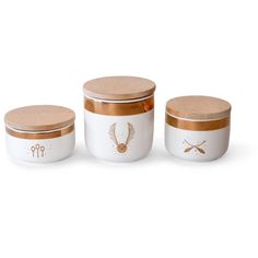 three white and gold canisters with wooden lids