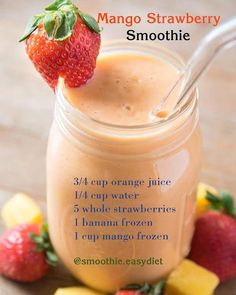 a smoothie in a mason jar with strawberries and mangoes on the side