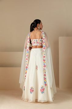 Off-White Thread Embroidered Lehenga Set, featuring a beautifully adorned bustier paired with a thread embroidered skirt and net dupatta. Complete with padding, full lining, and back hook opening, this set exudes elegance. Perfect for special occasions, it offers sophistication in every detail. Fitted Floral Embroidery Set For Ceremony, Fitted Sets With Floral Embroidery For Ceremony, Fitted Organza Choli For Ceremonies, Fitted White Choli For Ceremony, White Fitted Choli For Ceremony, Fitted Sets With Dori Work In Organza, Fitted Organza Sets With Dori Work, White Organza Lehenga For Ceremony, Fitted Organza Sets For Ceremonies