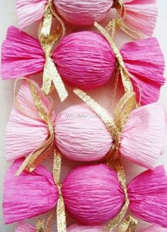 some pink balls with gold ribbons on them