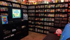 a room filled with lots of video games and gaming consoles on shelves next to each other