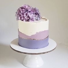 a white cake with purple flowers on top