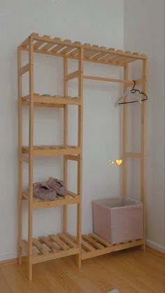 a wooden shelving unit sitting on top of a hard wood floor next to a white wall