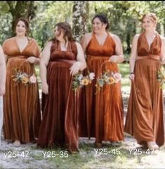 a group of women standing next to each other wearing dresses and holding bouquets in their hands