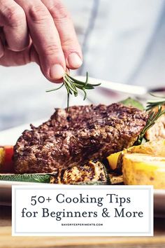 a person is sprinkling herbs on top of a steak with lemons and potatoes