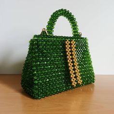 Discover our green evening bag, an original and luxurious, handmade beaded bag. This luxury beaded crossbody bag, personalized with emerald and gold crystal beads, embodies exclusivity and elegance. * Materials used  - Emerald green beads 8 mm (approximately 2500 beads used) - Gold colored beads (approximately 90 beads used) - Non-elastic nylon thread - 1 golden magnetic button - 1 golden shoulder chain - 2 D-rings (to hang the chain on the bag) * Dimensions 📏: - Width  24 cm / 9.45 inches - Height  15 cm / 5.91 inches - Depth  10 cm / 3.94 * USE & STYLE  Ideal for elegant evenings, special events or as a statement piece in a chic outfit. This bag goes perfectly with an evening dress or a formal outfit. Its generous size makes it easy to carry your daily essentials: smartphone, keys, smal Luxury Green Shoulder Bag For Formal Events, Cheap Green Beaded Shoulder Bag, Cheap Beaded Green Shoulder Bag, Cheap Square Beaded Bags, Cheap Beaded Square Bags, Beaded Crossbody Bag, Chain Dress, Green Handbag, Green Purse