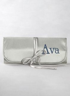 a silver purse with a blue logo on the front and white ribbon tied around it